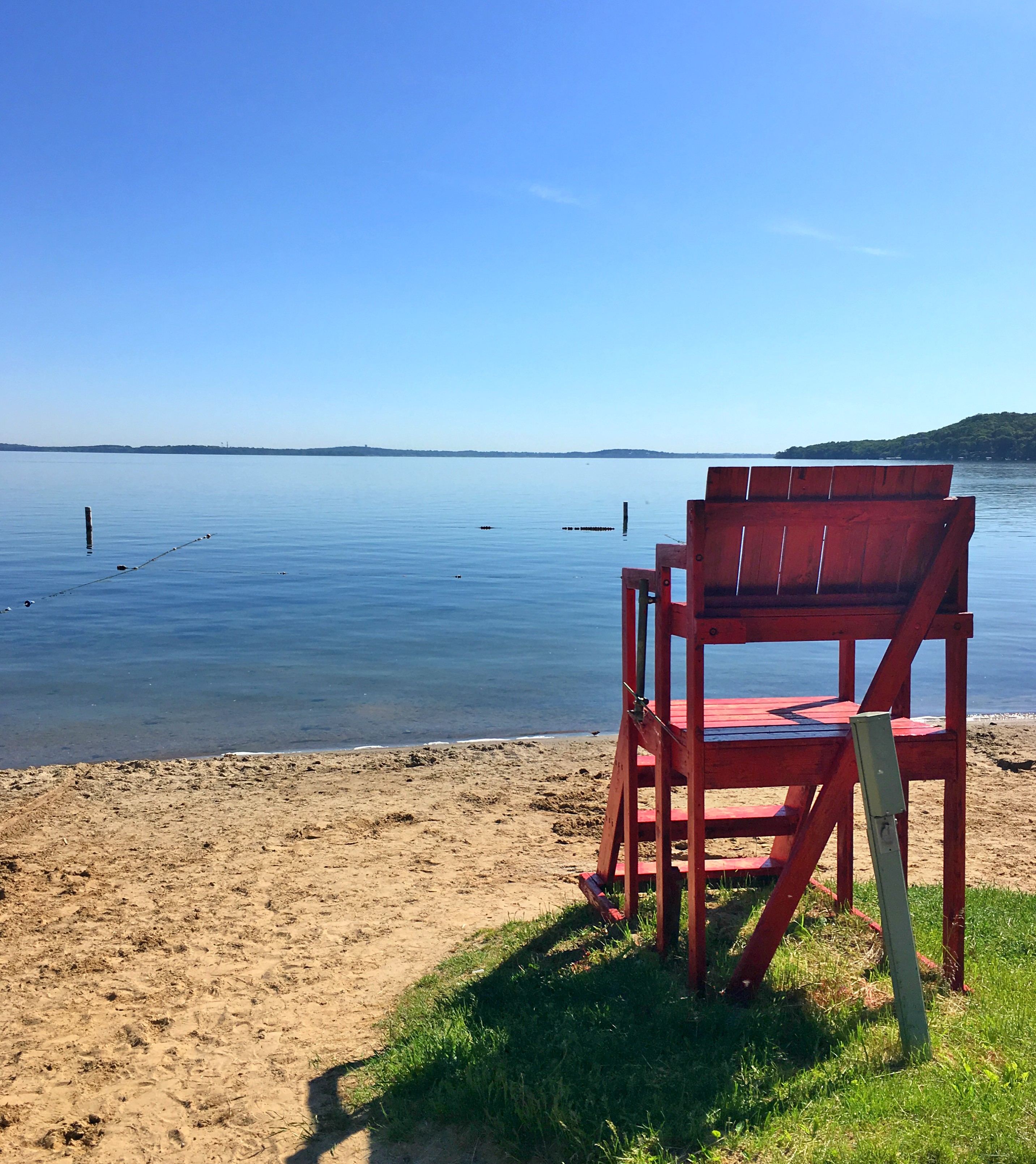 Lifeguard chair overlooking a sandy beach.