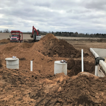 A digger moving dirt around a septic system