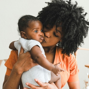 Parent kissing baby's cheek