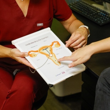 Provider showing patient an IUD