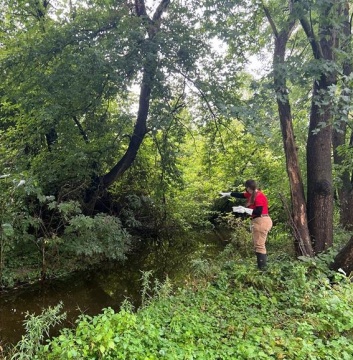 public health field staff person next to a creek