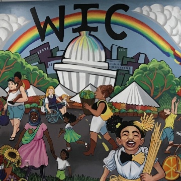 A mural of adults and children, the capitol building, and a rainbow.