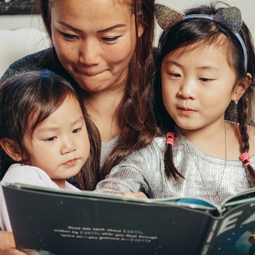 Parent reading book to children